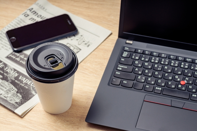 コーヒーとノートパソコンと新聞とスマートフォン